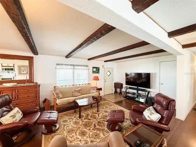 a living room with furniture a flat screen tv and a large window