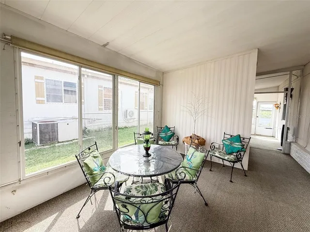 a dining room with furniture and large windows