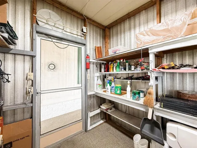 a kitchen with a refrigerator and a wooden floor
