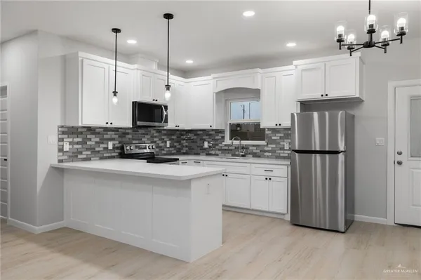 a kitchen with kitchen island white cabinets and stainless steel appliances