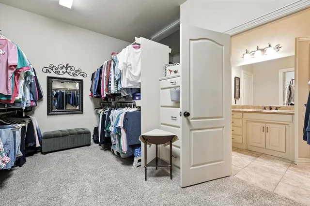 a view of walk in closet with clothes