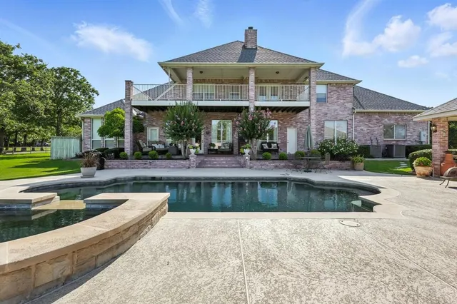 a view of a swimming pool with lawn chairs and a fire pit
