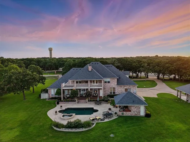 an aerial view of residential house with outdoor space and lake view in back