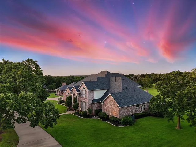 an aerial view of residential houses with outdoor space and trees