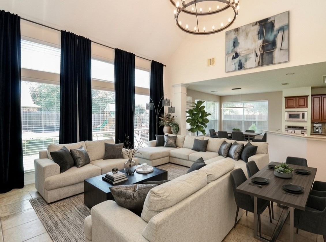 19802 Shavon Springs Drive Spring, TX 77388 - Photo 7 of 30 Virtullay staged living room setup idea high ceilings Bright and spacious living room featuring high ceilings and an elegant chandelier—perfect for relaxation and entertaining.
