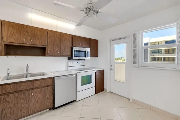 a view of a kitchen with a sink stove cabinet and a refrigerator