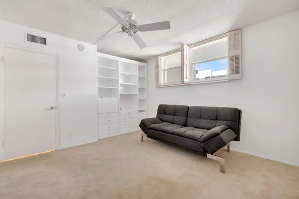a living room with furniture and a view of kitchen