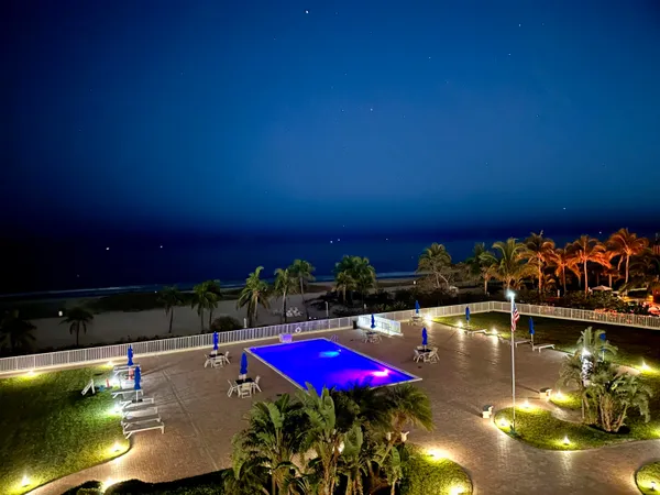 a front view of a house with a yard and swimming pool