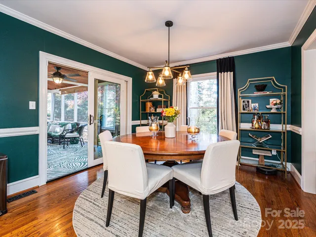 a dining room with furniture large windows and wooden floor
