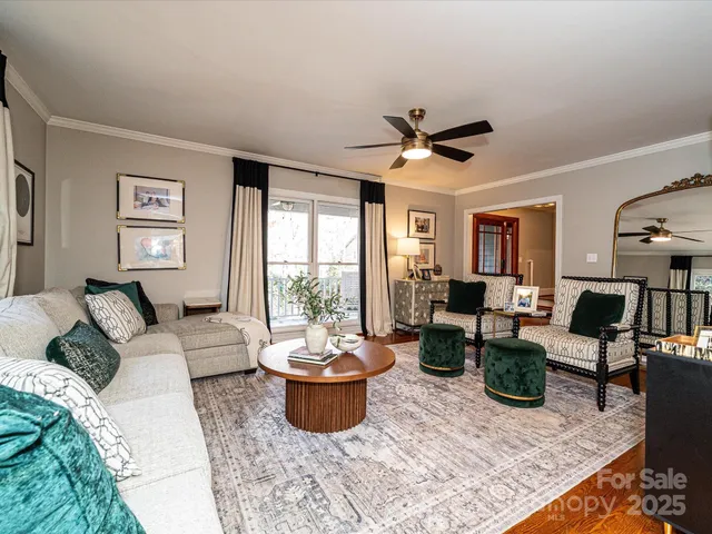 a living room with furniture potted plant and a large window