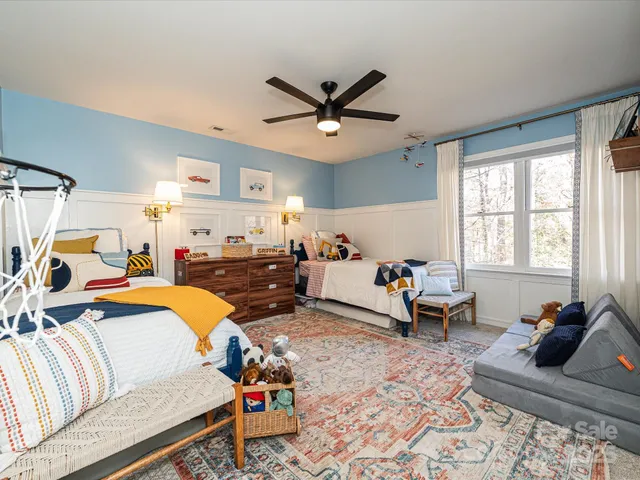 a bedroom with furniture and a large window