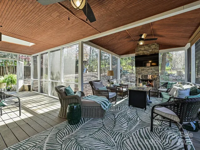 a living room with furniture fireplace and large windows