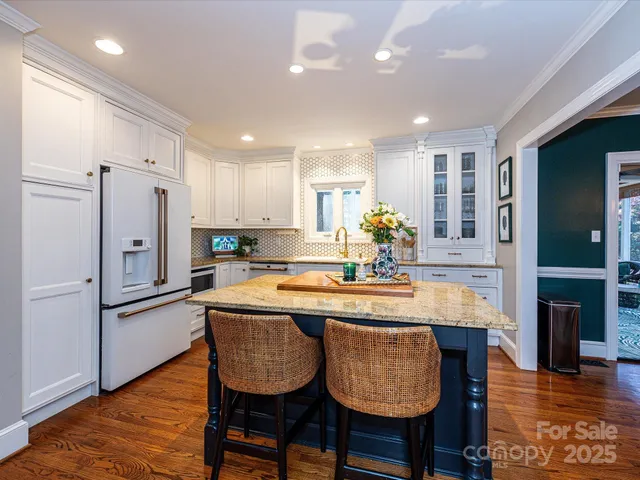a kitchen with granite countertop kitchen island stainless steel appliances a refrigerator a sink and a stove