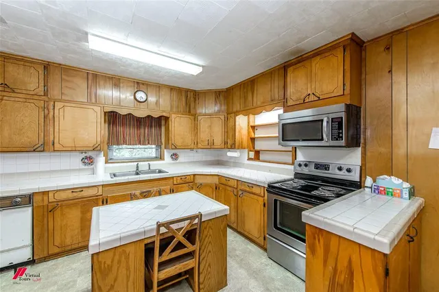 a kitchen with stainless steel appliances a stove a sink and a microwave