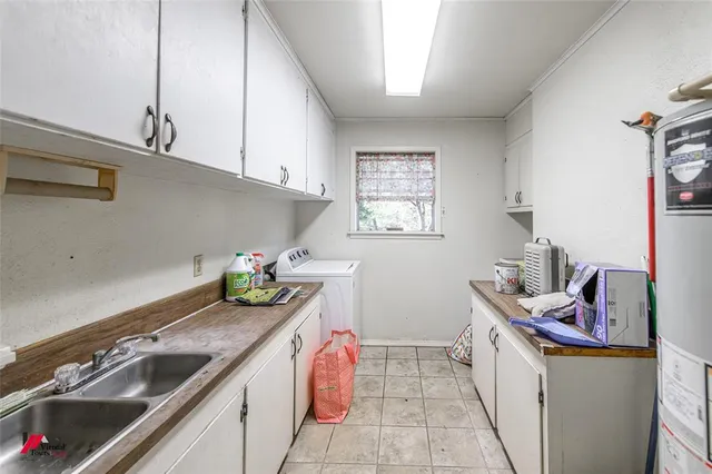 a utility room with sink and cabinets