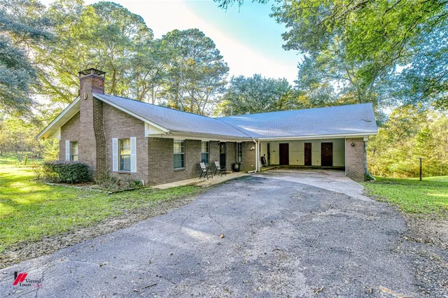 a view of a yard in front of a house with large tree