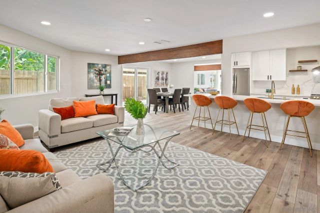 a kitchen with stainless steel appliances kitchen island granite countertop wooden floors and white cabinets