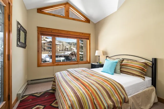 a bedroom with a bed and a large window with outer view