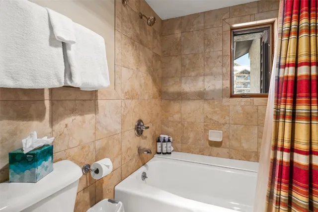 a bedroom with a bed and a flat tv screen next to a window