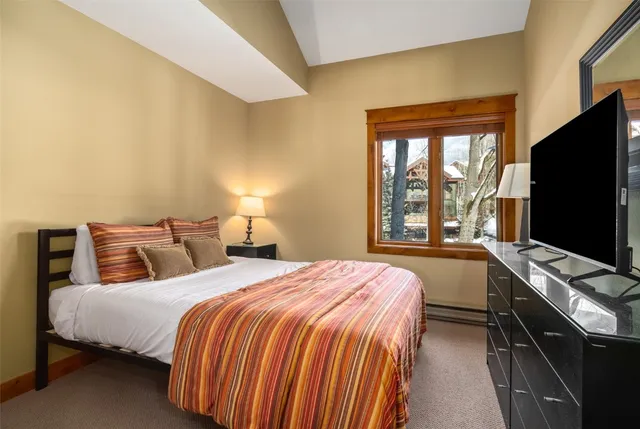 a bedroom with a bed and a flat screen tv