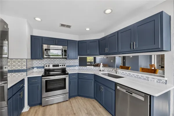 a kitchen with a stove sink and cabinets