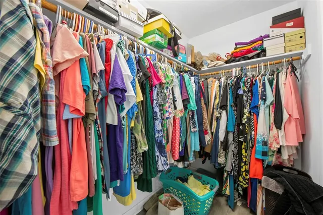 a view of walk in closet with clothes