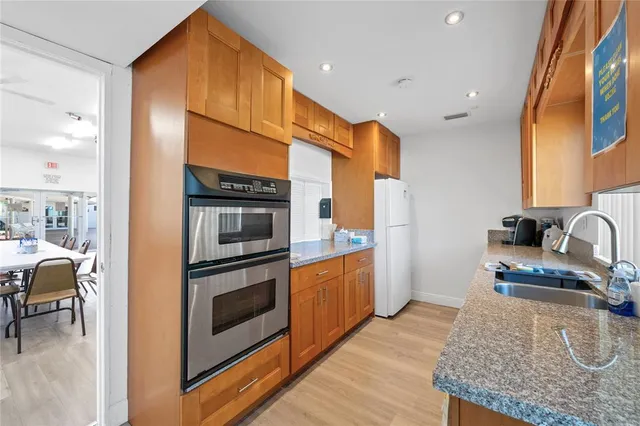 a kitchen with stainless steel appliances granite countertop a stove a sink and a refrigerator