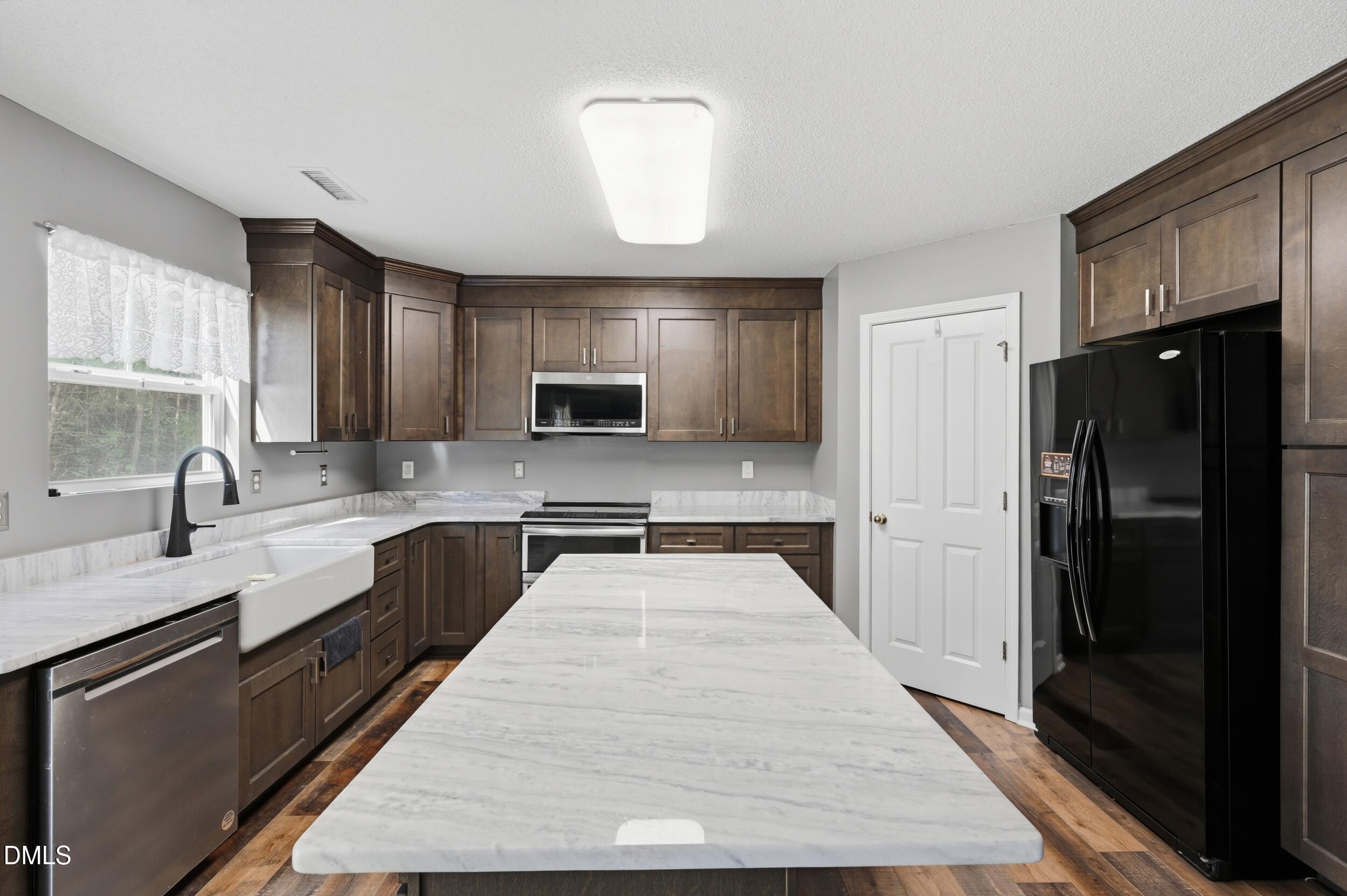 148 Brockton Ridge Drive Garner, NC 27529 - Photo 13 of 39 a large kitchen with granite countertop a refrigerator a sink dishwasher a stove with wooden cabinets and floor
