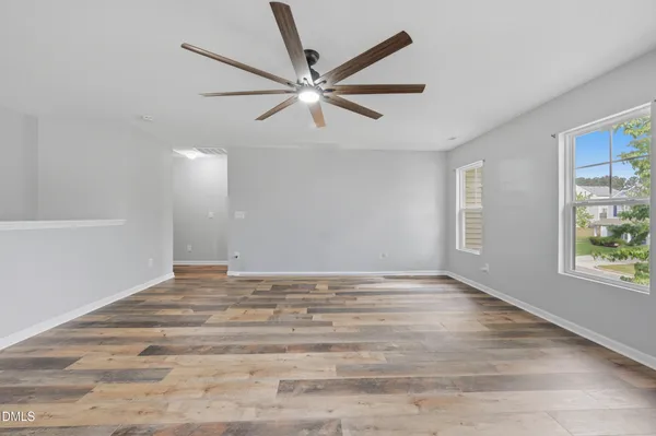 a large kitchen with granite countertop a refrigerator a sink dishwasher a stove with wooden cabinets and floor