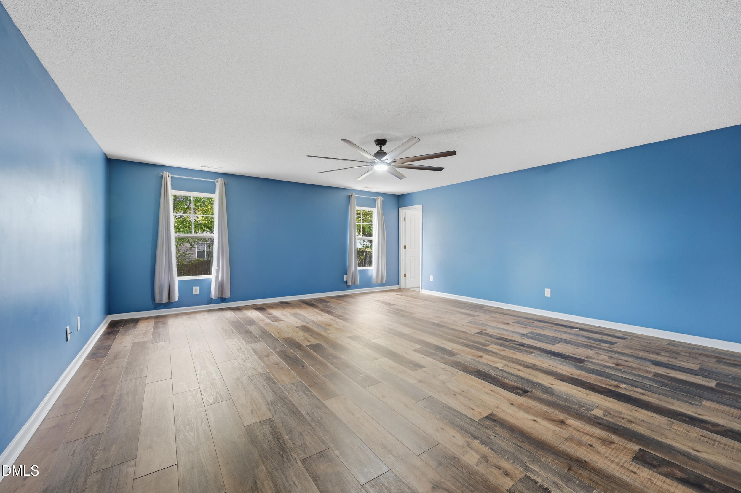 148 Brockton Ridge Drive Garner, NC 27529 - Photo 19 of 39 a view of an empty room with wooden floor and fan