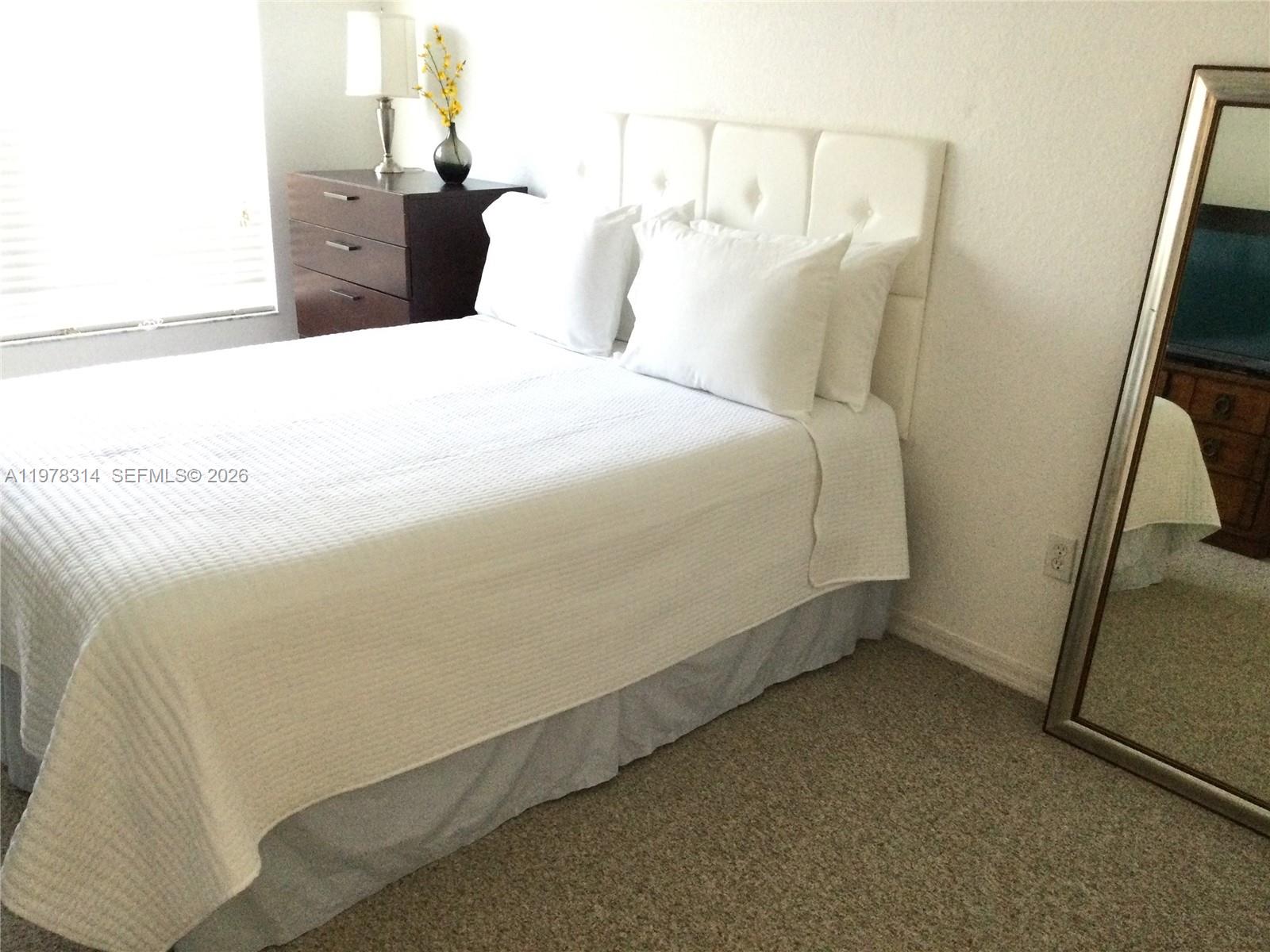 4601 Yellowgold Road West, Unit B8104 Kissimmee, FL 34746 - Photo 13 of 16 a bed sitting in a bedroom next to a window