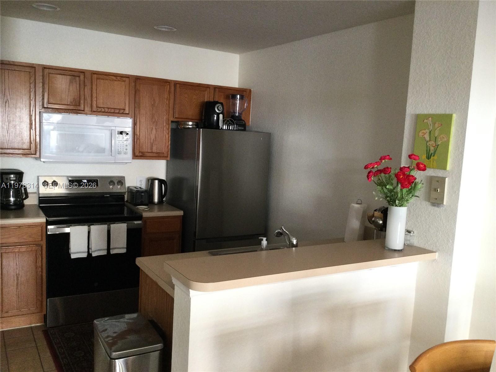 4601 Yellowgold Road West, Unit B8104 Kissimmee, FL 34746 - Photo 4 of 16 a kitchen with a refrigerator and a stove