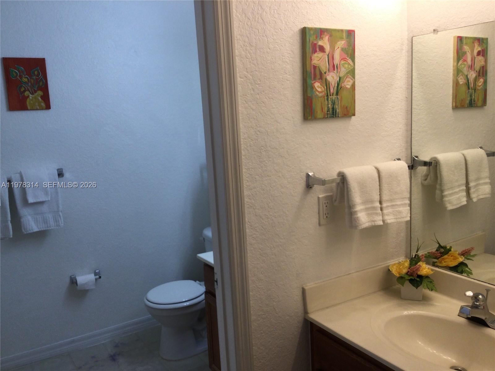 4601 Yellowgold Road West, Unit B8104 Kissimmee, FL 34746 - Photo 10 of 16 a bathroom with a sink toilet and mirror