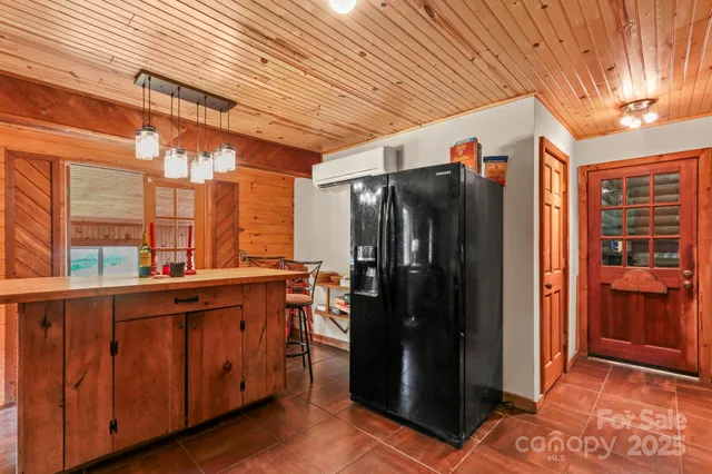 a view of a refrigerator in kitchen and a wooden fence