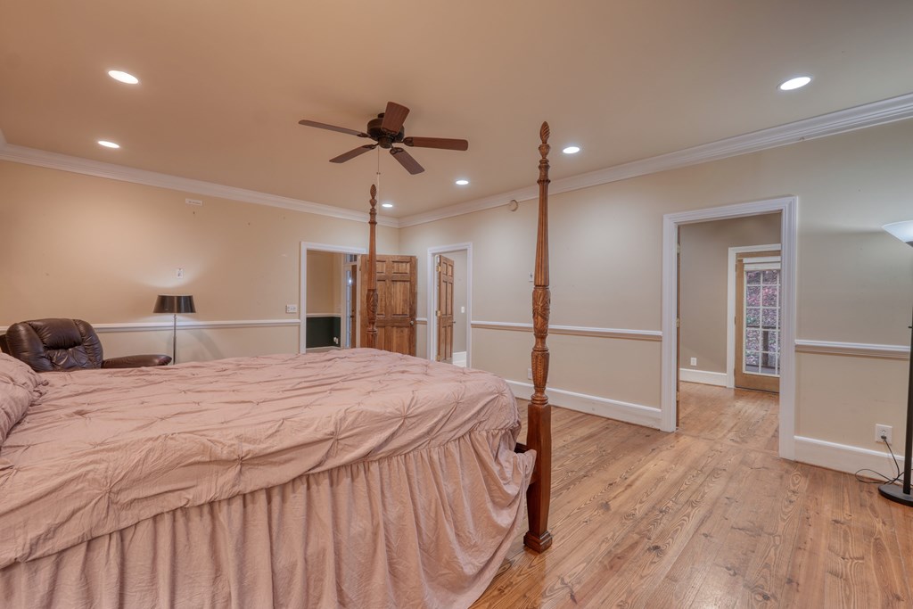 1837 Deep South Farm Road Blairsville, GA 30512 - Photo 34 of 76 a spacious bedroom with a bed and a chandelier