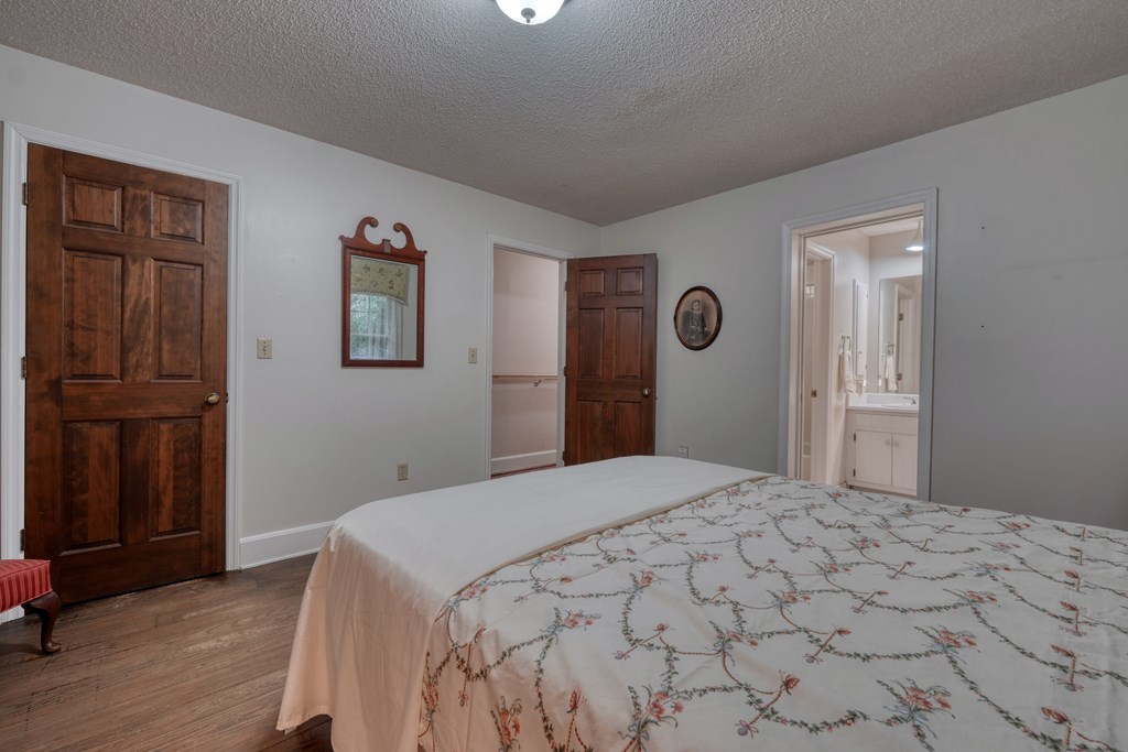 1837 Deep South Farm Road Blairsville, GA 30512 - Photo 43 of 76 a bedroom with a large bed and wooden floor