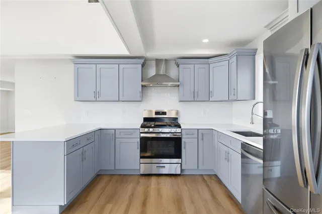 a kitchen with stainless steel appliances granite countertop a stove a sink and a refrigerator