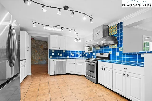 a kitchen with stainless steel appliances kitchen island granite countertop a stove a sink and cabinets