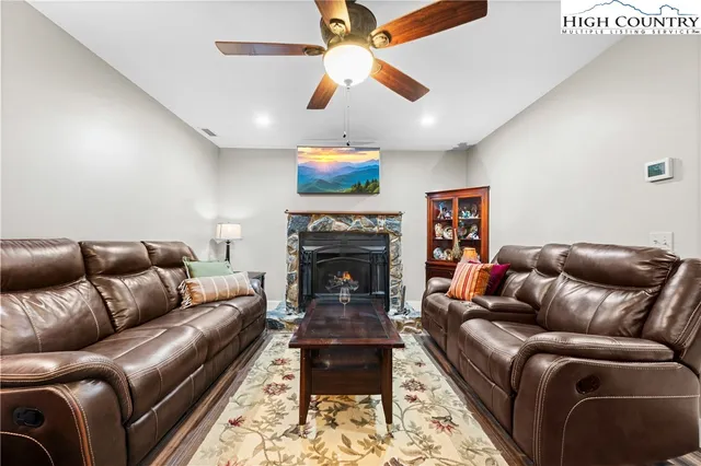 a living room with furniture a flat screen tv and a fireplace