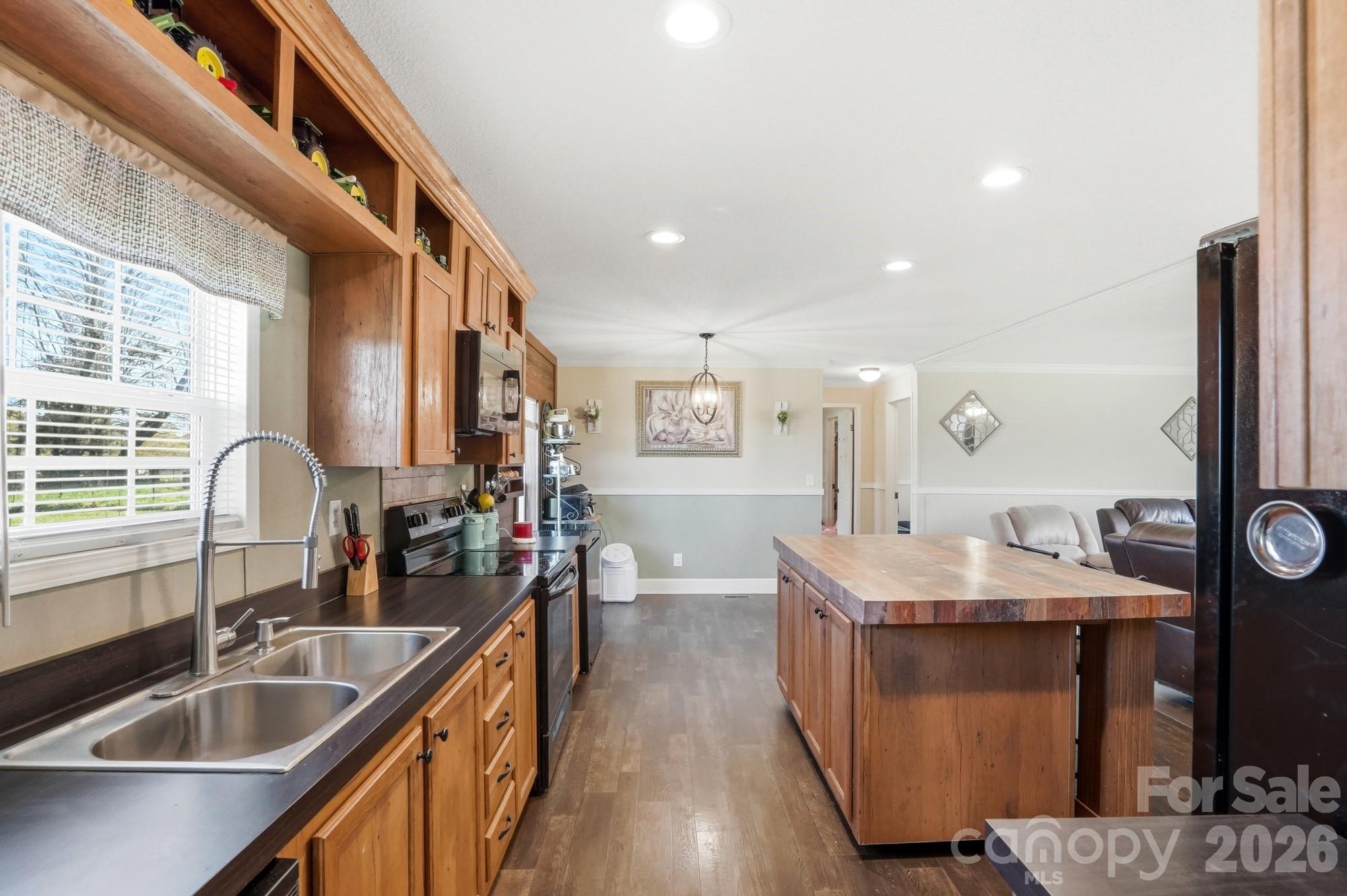4111 Clontz Taylor Road Marshville, NC 28103 - Photo 12 of 27 a kitchen with stainless steel appliances granite countertop a sink a stove and a wooden cabinets
