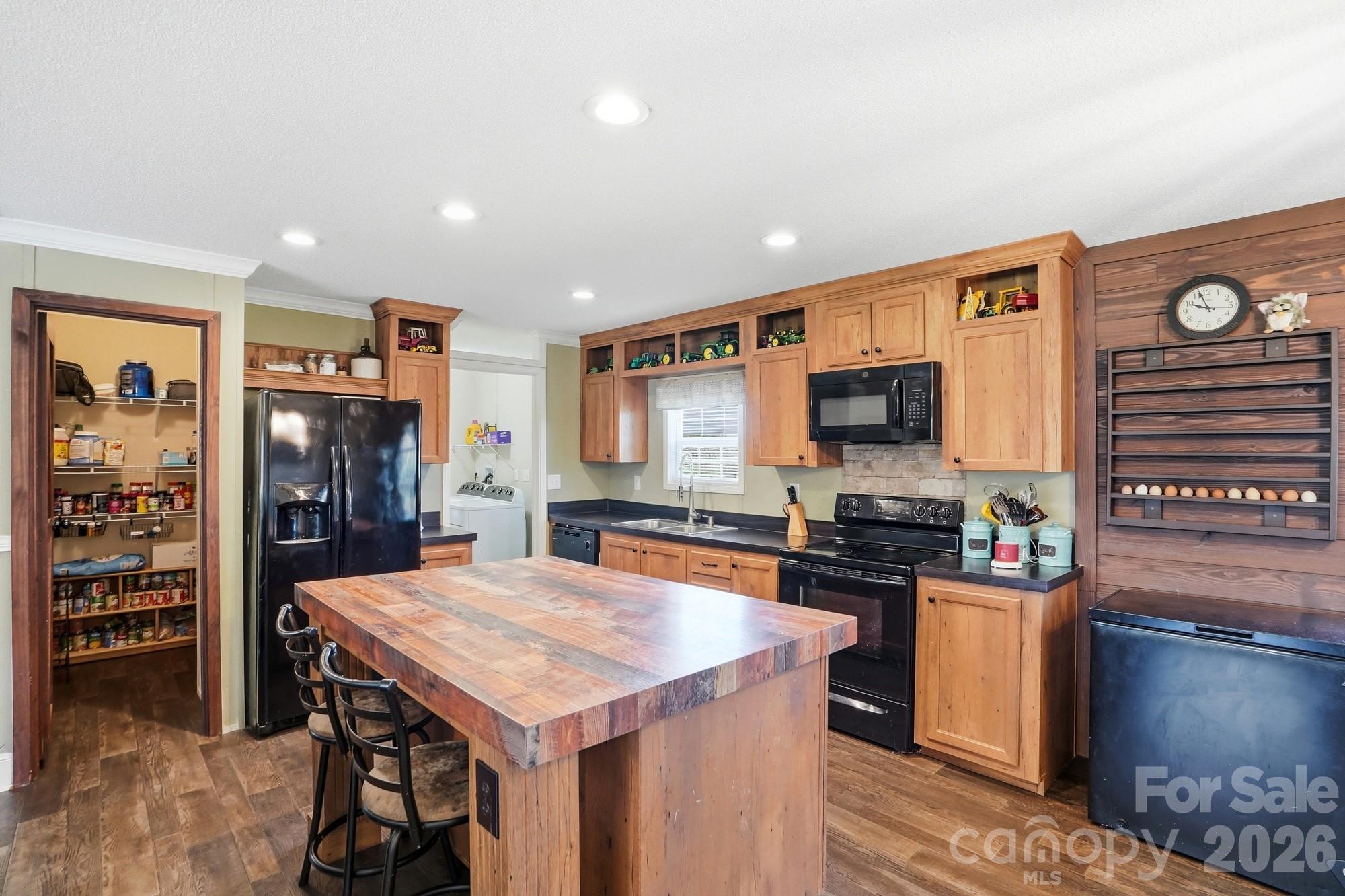 4111 Clontz Taylor Road Marshville, NC 28103 - Photo 9 of 27 a kitchen with stainless steel appliances granite countertop a stove top oven a sink a dining table and chairs with wooden floor