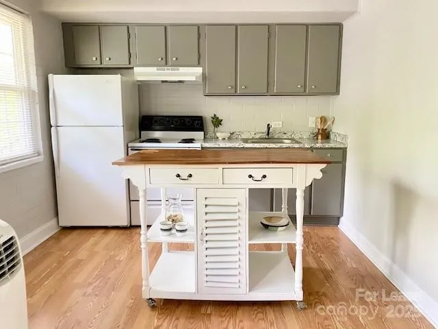 a kitchen with a refrigerator and a stove top oven