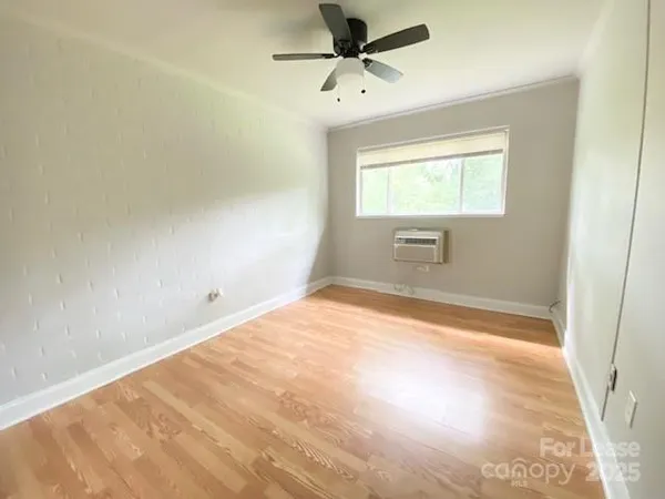 a view of empty room with window and ceiling fan