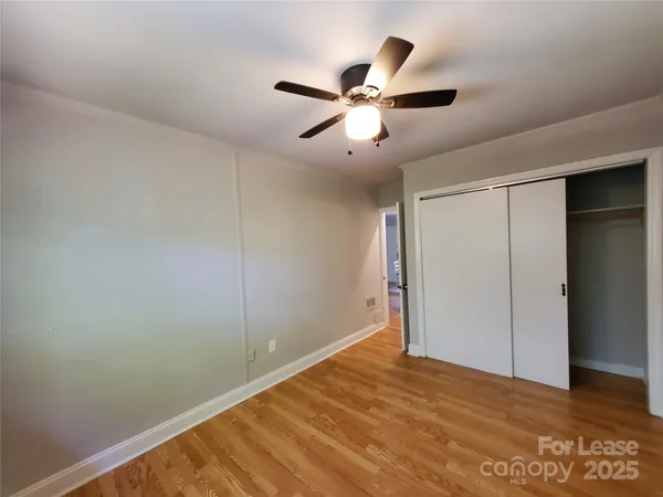 a view of a big room with wooden floor and closet in a room