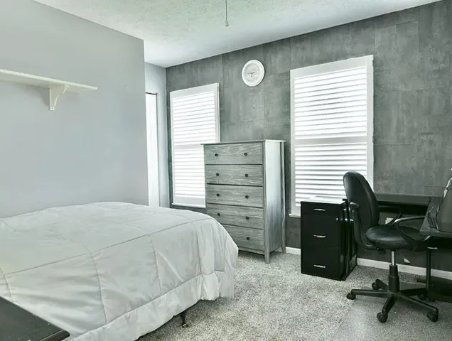a bedroom with a bed and a desk