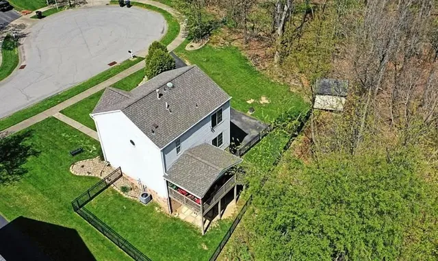an aerial view of a house with a yard