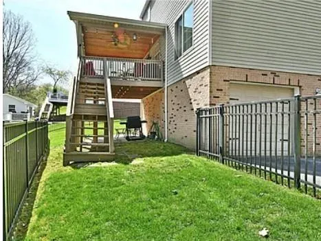 a view of a house with a yard and wooden fence