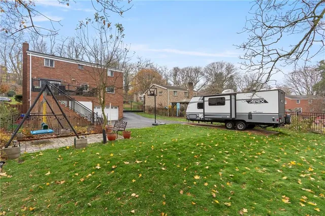 a view of a house with backyard and a tree