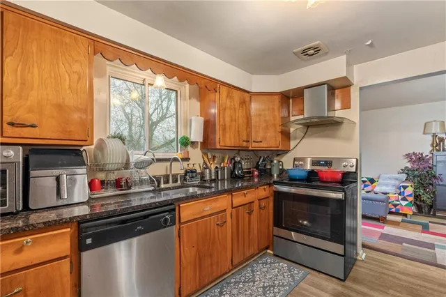 a kitchen with stainless steel appliances granite countertop a sink stove and cabinets