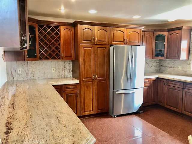 a kitchen with stainless steel appliances granite countertop a refrigerator and a sink